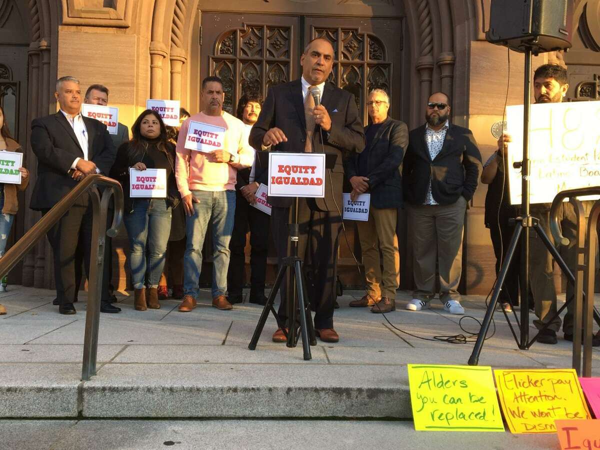 Abraham Hernandez addresses the press with members of the Latino community in the background outside City Hall.