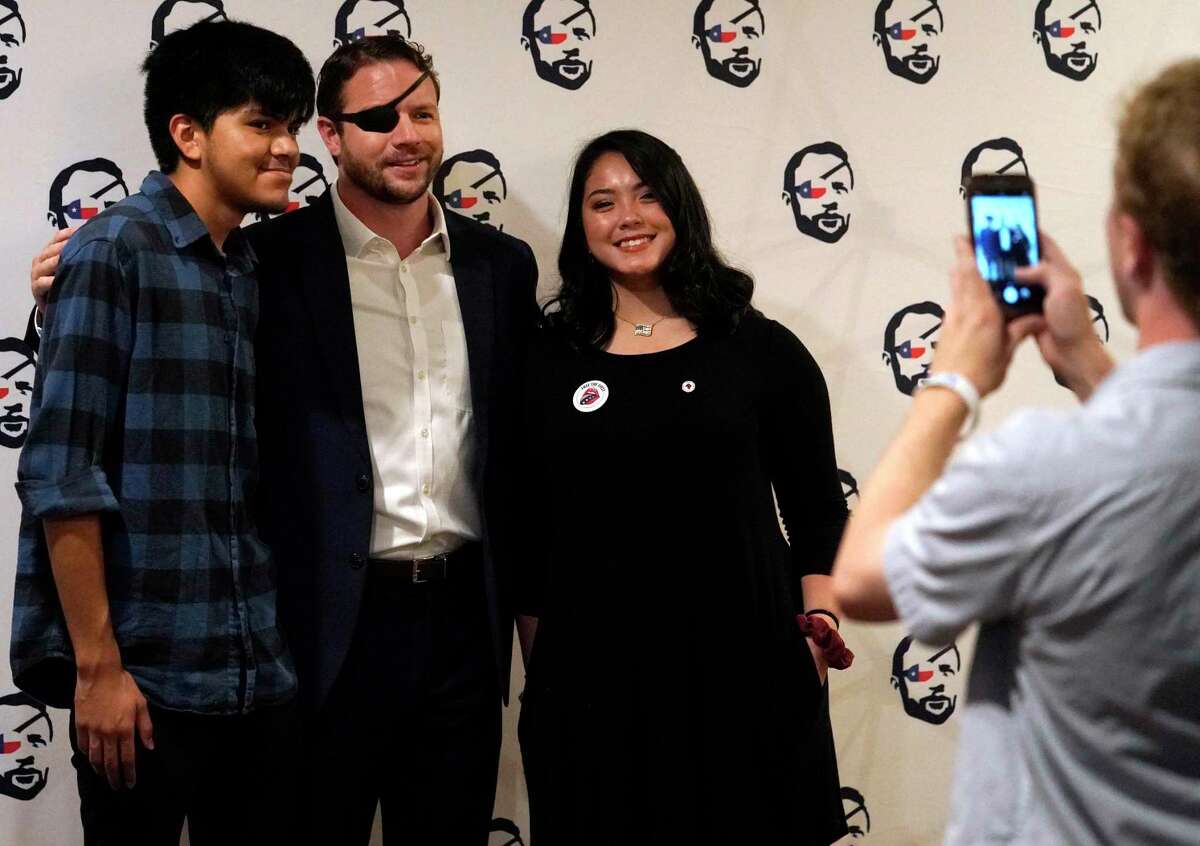 Roman Molina 17, left, and his girlfriend, Madyson Duong, 17, both of Katy, pose for a photo with Congressman Dan Crenshaw during his Youth Summit held at the Hyatt Regency Houston, 1200 Louisiana St., Sunday, Sept. 15, 2019, in Houston. The event was for high school and college students.