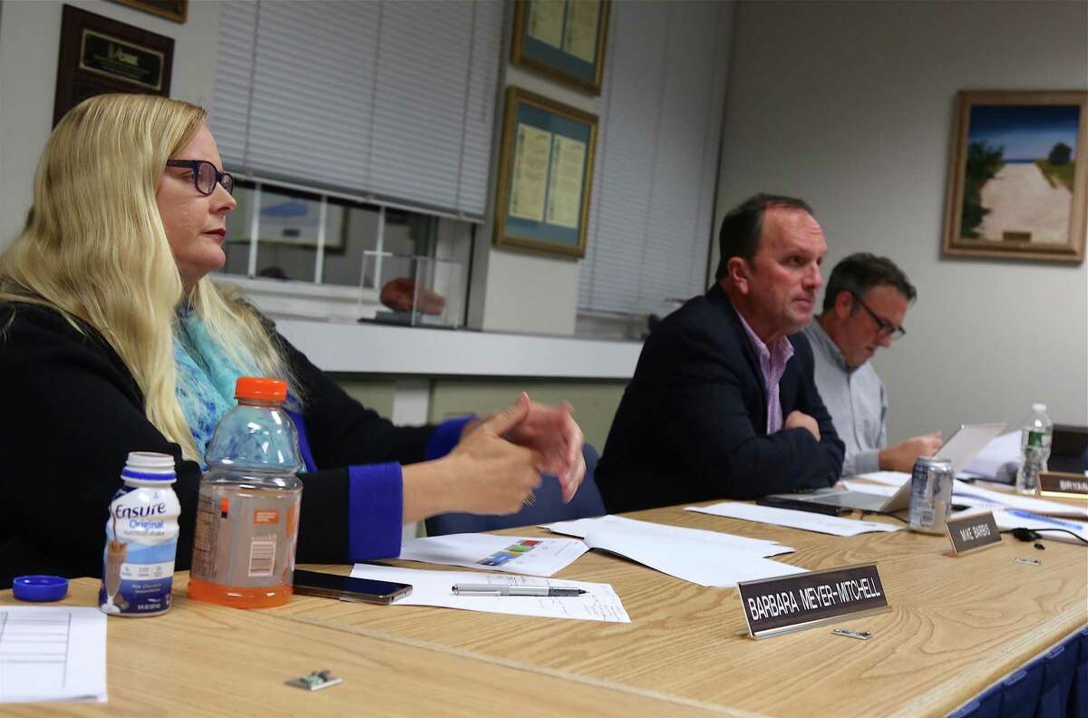 Board of Education members Barbara Meyer-Mitchell and Chairman Mike Barbis listen to updates on facilities at Monday's meeting.