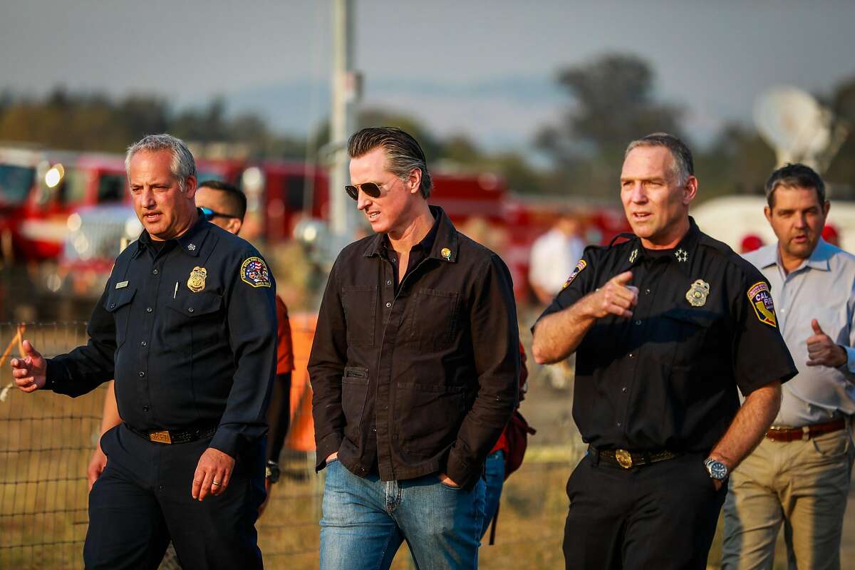 Gov. Gavin Newsom chats with firefighters at the Sonoma County Fairgrounds where people have gone to evacuate from the Kincade fire in Santa Rosa, California, on Monday, Oct. 28, 2019.