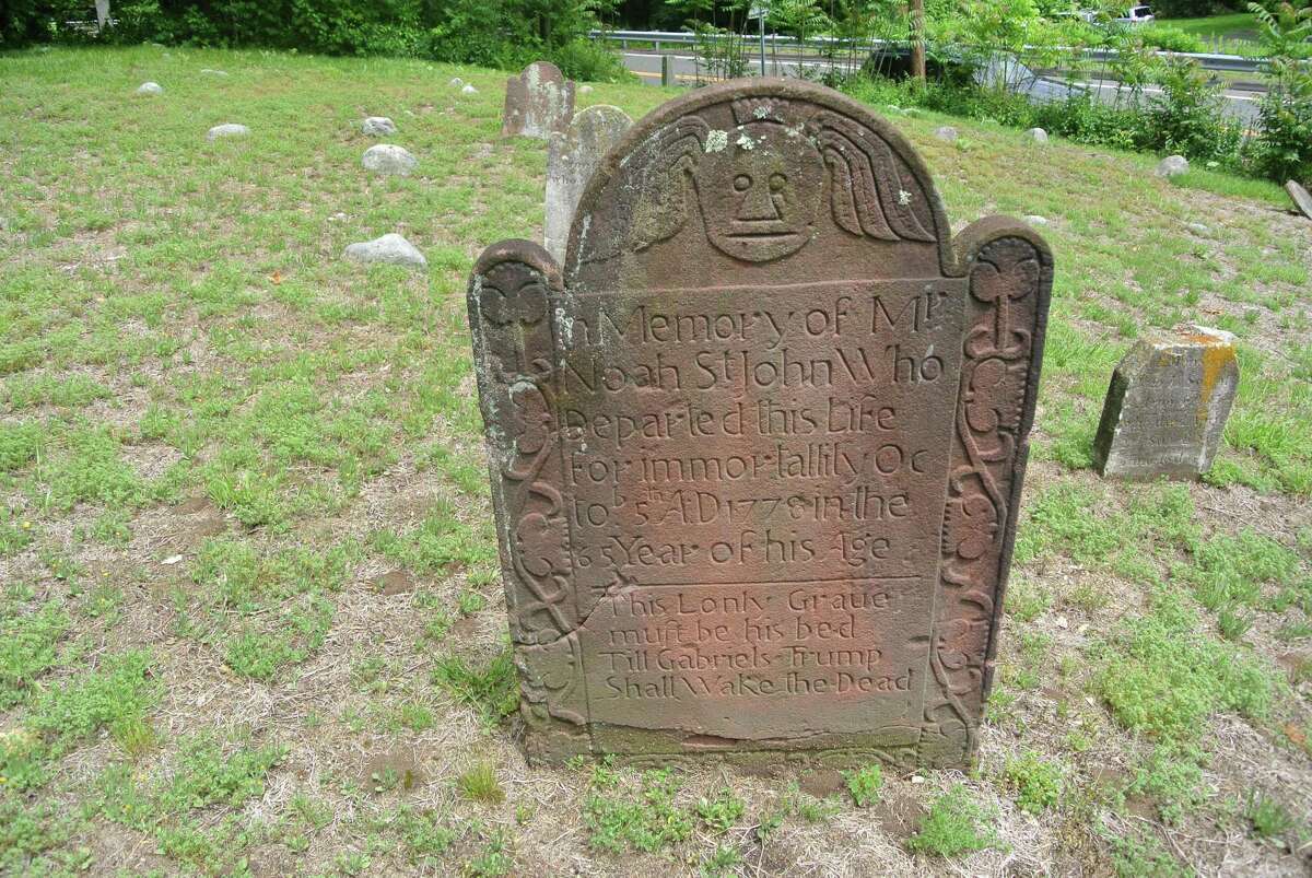 A stone marks the resting place of Noah St. John at the Sharp Hill Cemetery in Wilton, Conn.