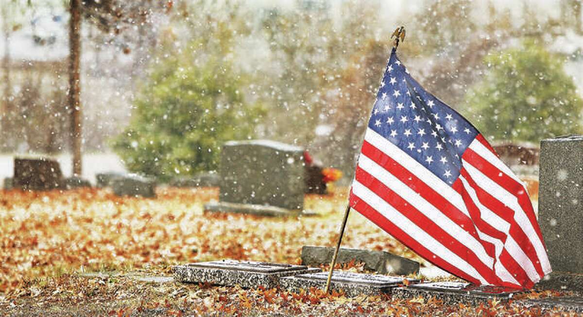 A larger sized flag flies Thursday over the grave of a 23-year-old U.S. Navy ensign who died during World War II, as the snow blows through the Upper Alton Cemetery. Friday was the 77th anniversary of the Japanese attack on the U.S. Naval Base at Pearl Harbor which killed 2,335 American servicemen, 2,008 of those were Navy personnel. The attack launched the U.S. into the second World War.