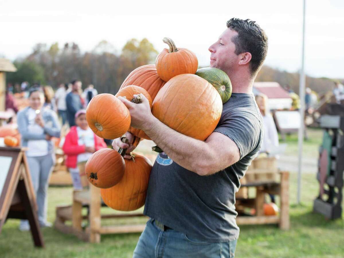 EJ Maher carries a handful of pumpkins.