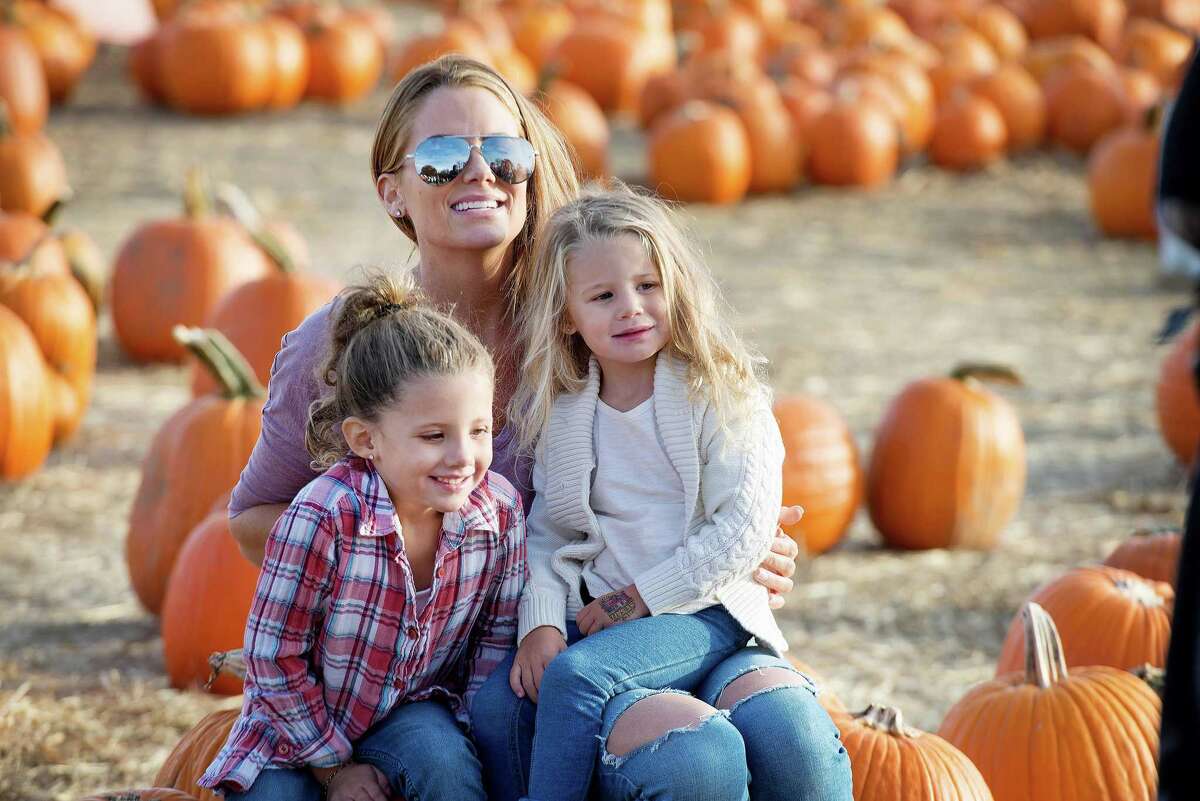 Sandi Staley, Ariana,5, and Alivia, 3, enjoy pumpkin picking at Children's Festival for Unicef at the Jones Family Farm on Saturday.