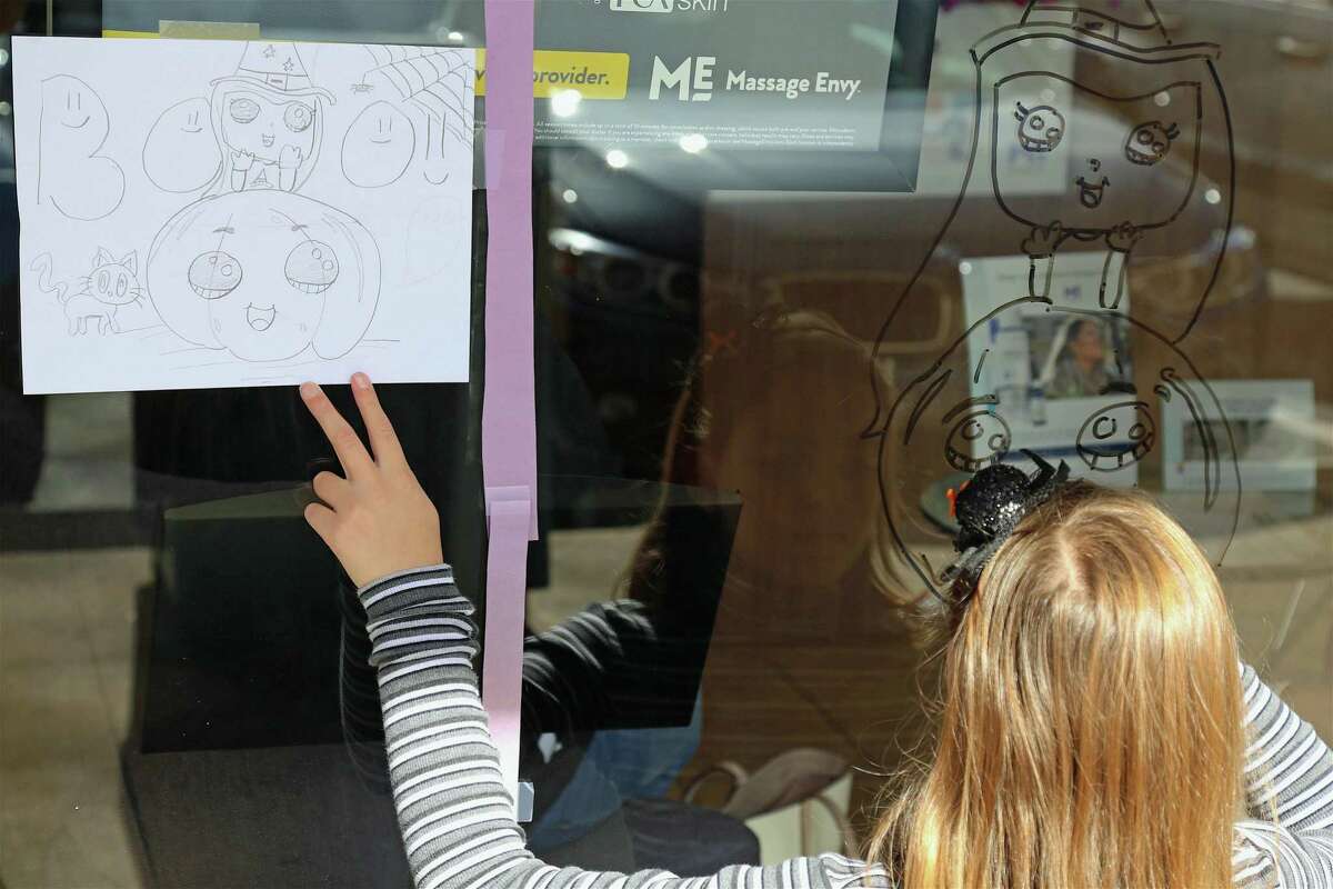 Hailey Kipperman, 10, of Weston, copies from her original design at the Chamber of Commerce's annual Halloween window decorating contest on Saturday, Oct. 26, 2019, in Westport, Conn.