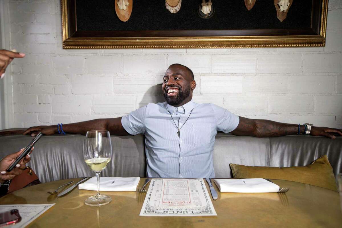 Houston Texans linebacker Whitney Mercilus laughs with Tamara Washington, who handles his public relations, during a photo shoot at State of Grace, one of his favorite Houston restaurants.