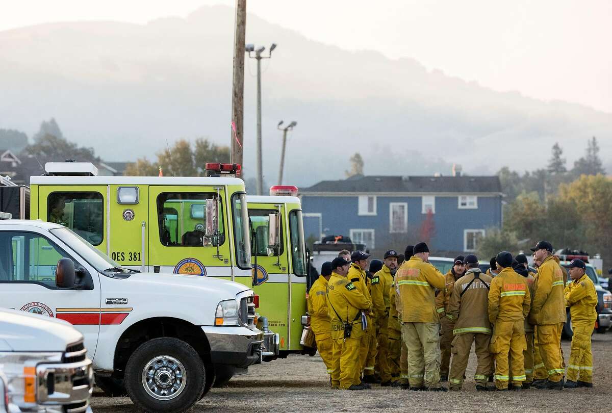 Firefighters huddle up to plan their day before heading out from the Kincade Fire incident base at the Sonoma County Fairgrounds in Santa Rosa, Calif. Tuesday, Oct. 29, 2019.