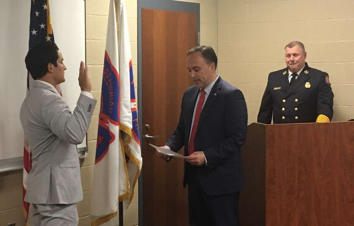 Firefighting recruit Scott Teulings takes the oath of office from First Selectman Peter Tesei, as Fire Chief Peter Siecienski looks on.