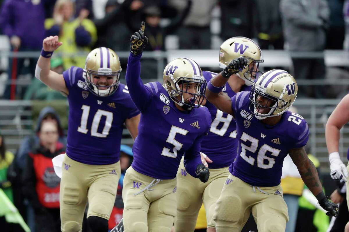 Washington's Andre Baccellia (5) celebrates his five-yard touchdown reception against Oregon with Jacob Eason (10), Cade Otton and Salvon Ahmed (26) in the first half of an NCAA college football game Saturday, Oct. 19, 2019, in Seattle.