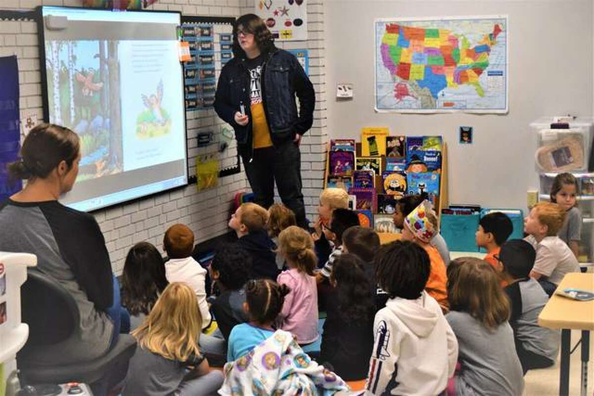 An Edwardsville High School student reads the English version of “The Gruffalo” to students at Nelson Elementary School on Friday.