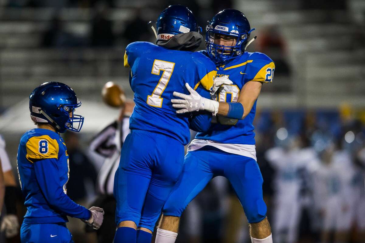 Midland's Carter Thomas, left, and Eli Gordon, right, celebrate after a play during the Chemics' Division 2 regionals game against Muskegon Mona Shores Friday, Nov. 2, 2019 at Midland Community Stadium. (Katy Kildee/kkildee@mdn.net)