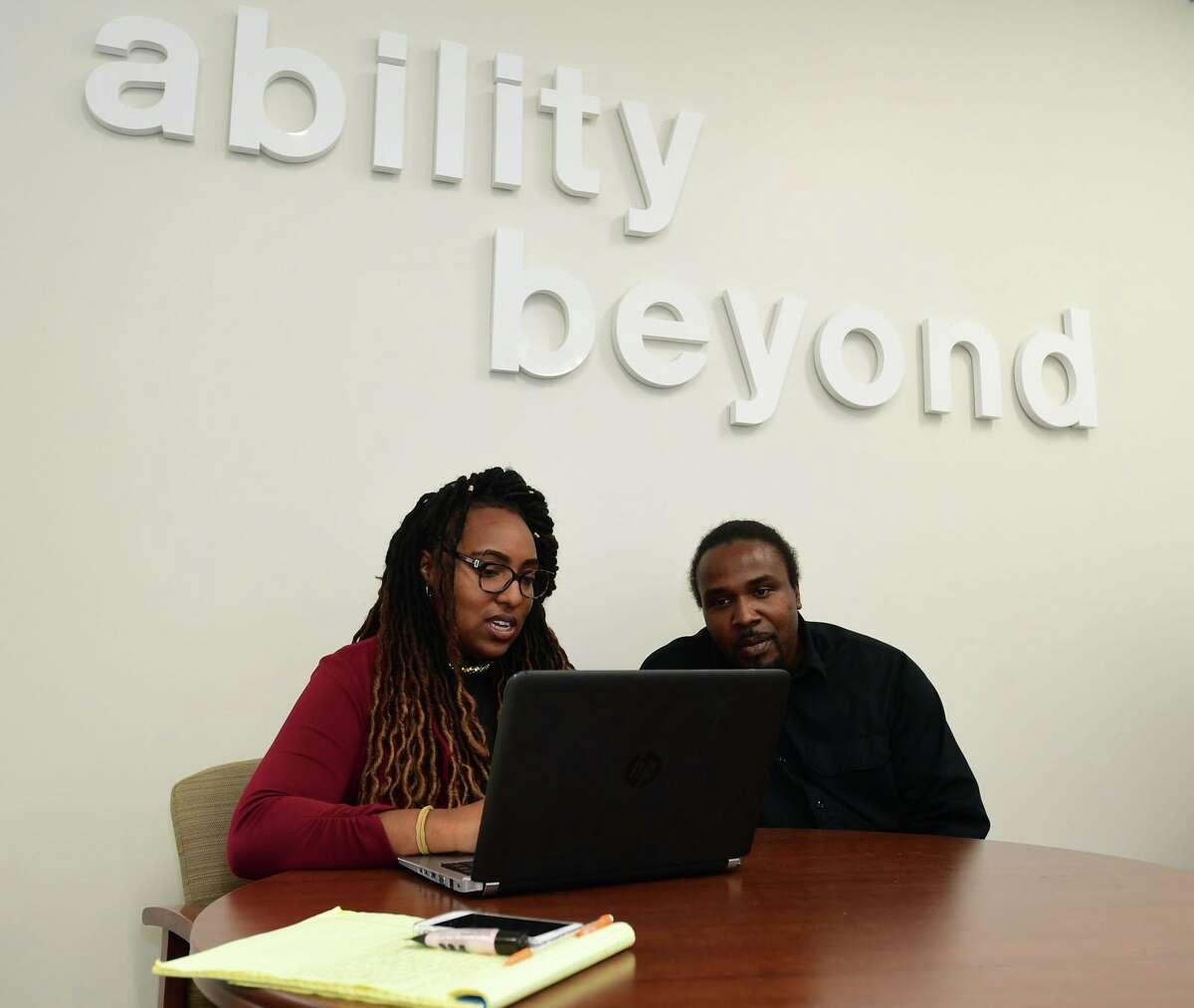 Employment Specialist Chenelle James helps client Earl Melton at The Bethel-based disabilities services giant, Ability Beyond facility in Norwalk, Conn. October is national disabilities awareness month.