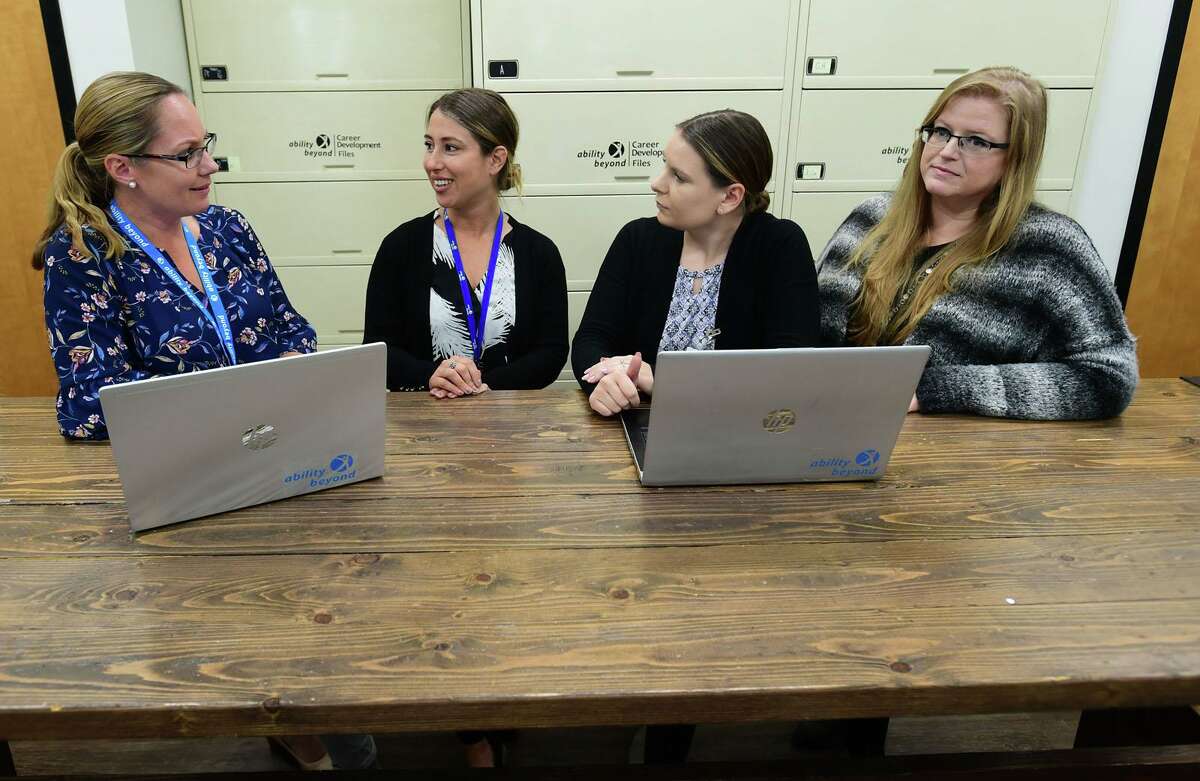 Employees including Kate Travis, Jennifer Pratt, Kaitlyn Appley and Amber Sullivan discuss their clients at The Bethel-based disabilities services giant, Ability Beyond facility in Norwalk. October is national disabilities awareness month.