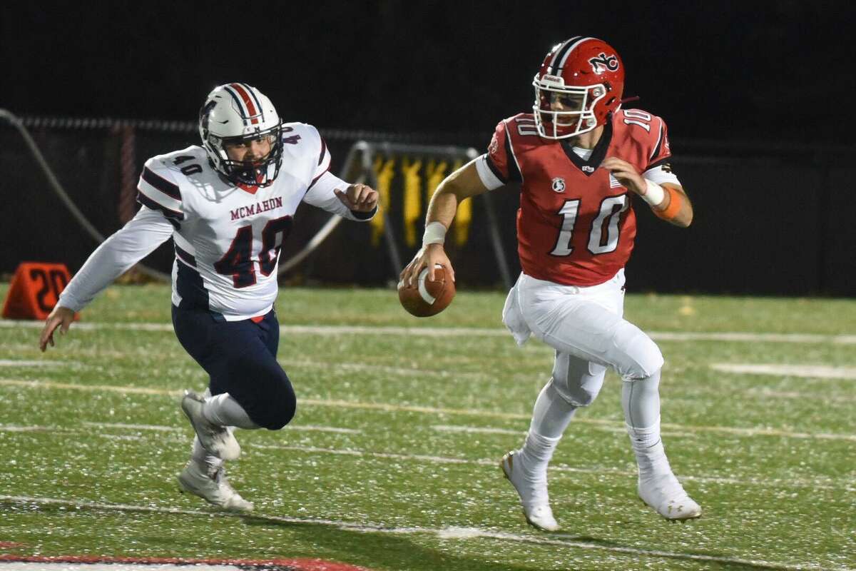 New Canaan QB Drew Pyne (10) scrambles away from Brien McMahon’s Jeffrey Cocchia (40) during a football game at Dunning Field in New Canaan on Friday, Nov. 1, 2019.