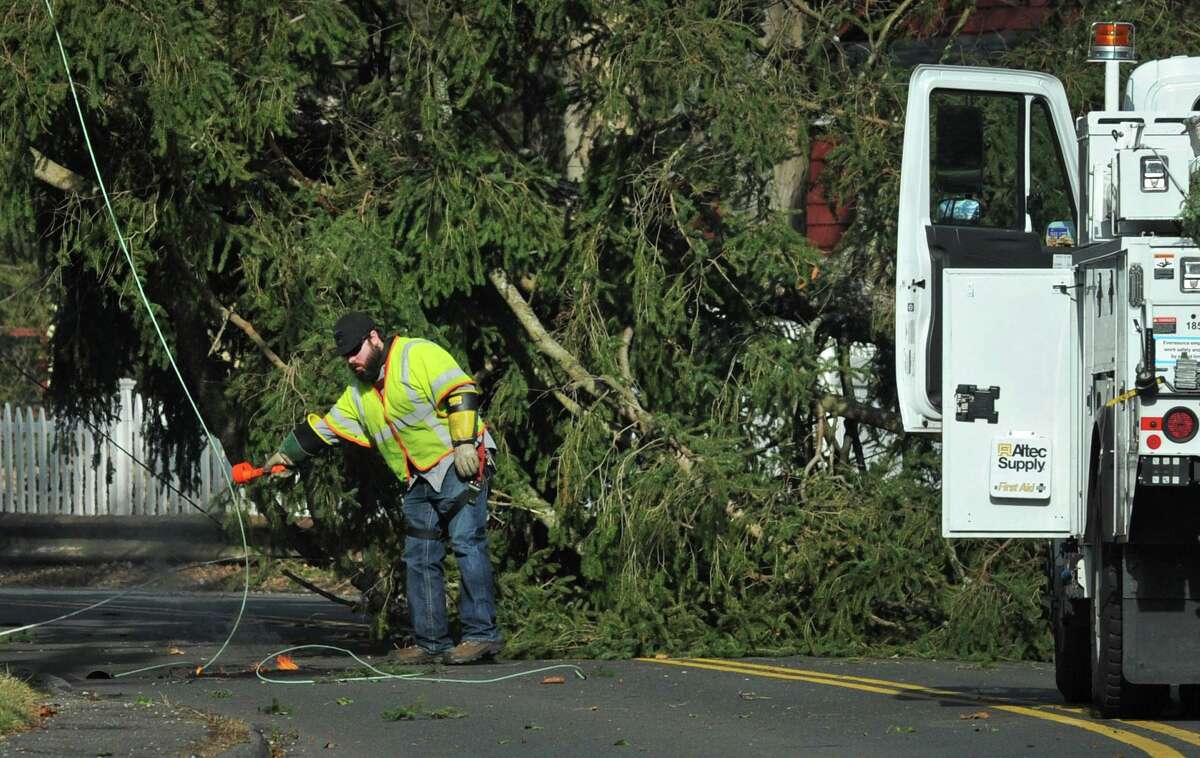 A Eversource employee checks the status of a downed wire along Silvermine Avenue Wednesday, January 9, 2019, after a pine tree came down across the road in Norwalk, Conn.