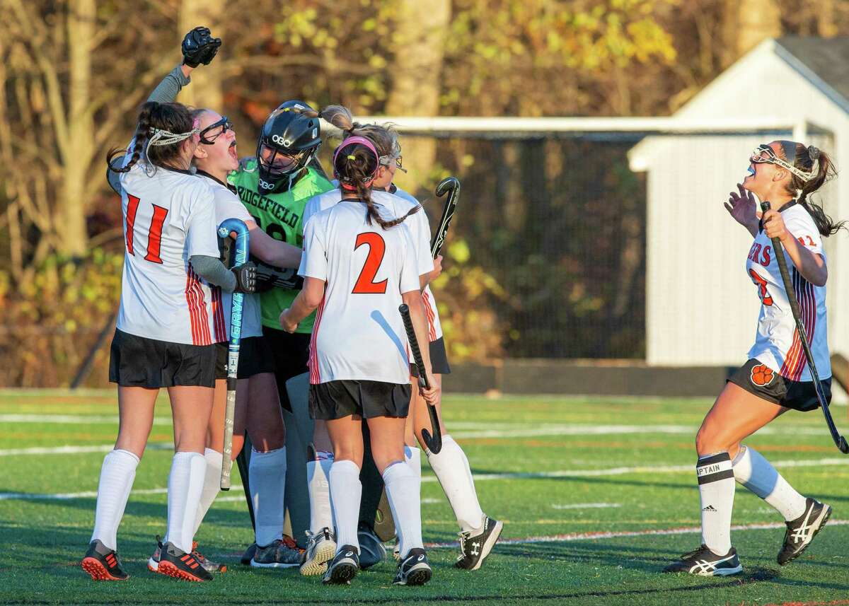 The Ridgefield field hockey team celebrates at the end Friday's 1-0 win over Wilton in the FCIAC quarterfinals.