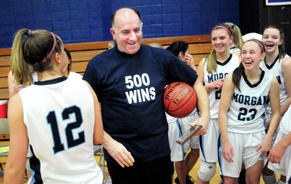 Morgan girls basketball coach Joe Grippo (center) wears a t-shirt given to him in honor of his 500th win in 2012.