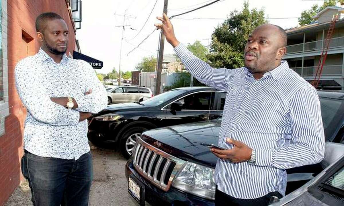 John Matanda (right), who was recently elected the president of the Congolese Community of Champaign County, and Robson Kiyangi, second vice president, discuss plans for the organization outside their office on Griggs Street in Urbana.