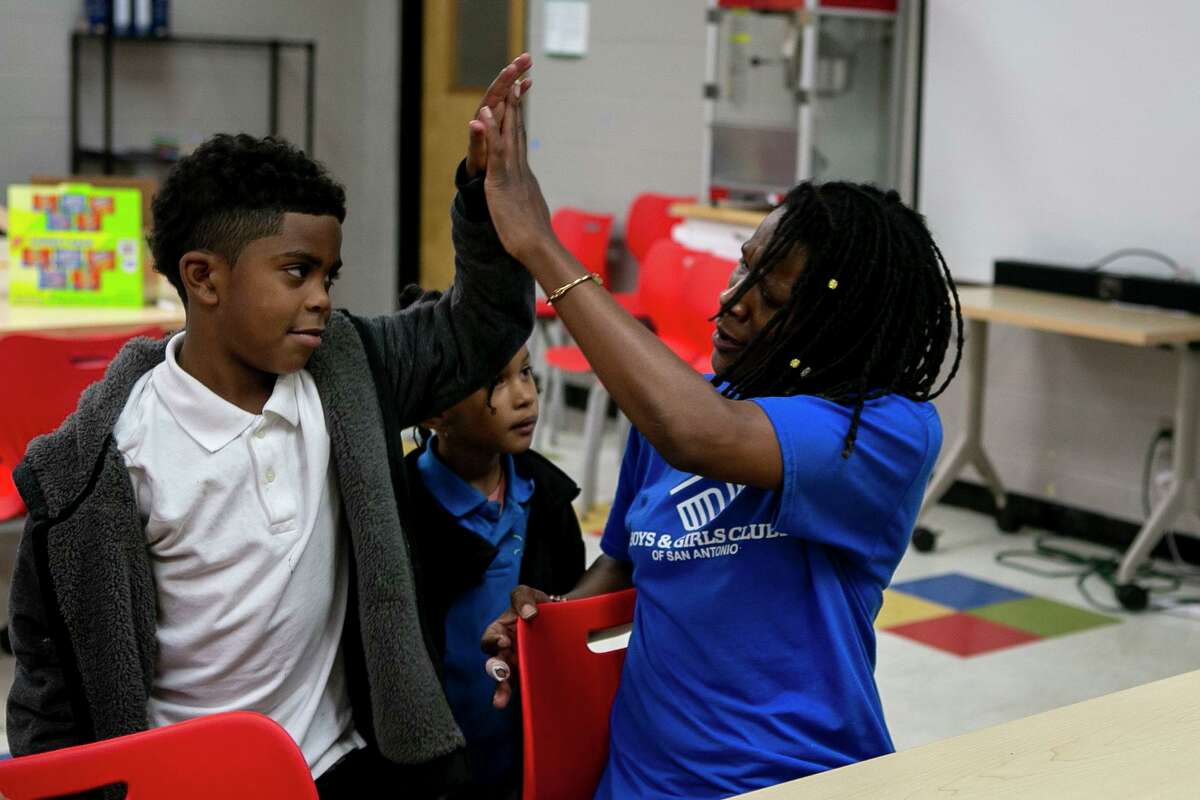 Tamarya Guess, 44, high fives Noah Stacy Beamer, 7, at the Eastside Branch of the Boys & Girls Clubs of San Antonio in San Antonio, Texas, on Oct. 21, 2019.