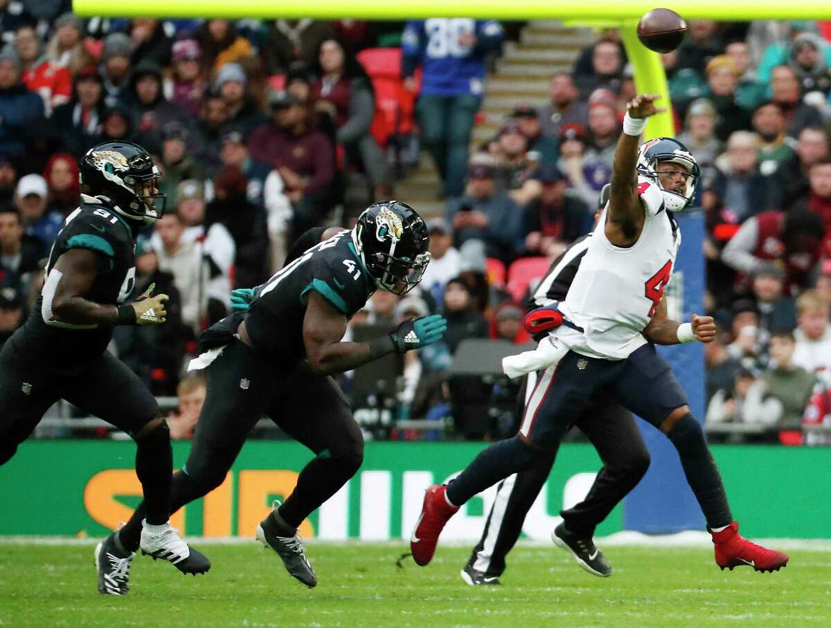 Houston Texans quarterback Deshaun Watson (4) releases a pass as he is chased out of the pocket by Jacksonville Jaguars defensive end Yannick Ngakoue (91) and defensive end Josh Allen (41) during the second quarter of an NFL football game at Wembley Stadium on Sunday, Nov. 3, 2019, in London.