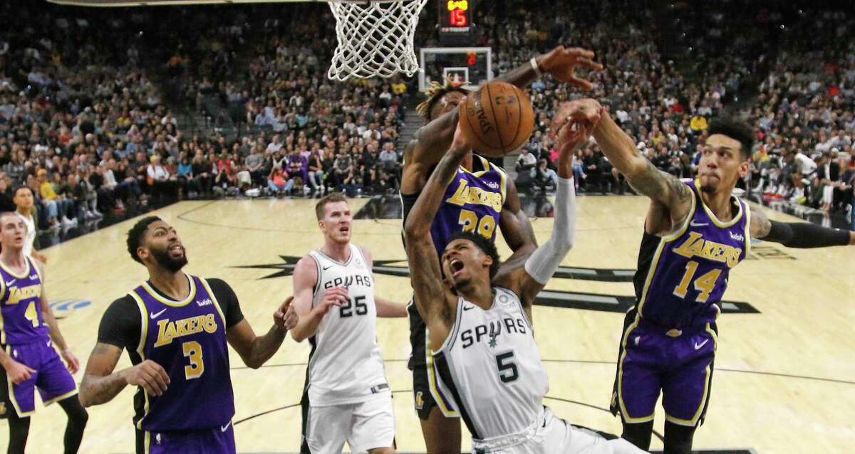 Dejounte Murray (5) of the Spurs has his shot blocked by Dwight Howard (39) of the Los Angeles Lakers and Danny Green (14) on Sunday, Nov. 3, 2019 at the AT&T Center.