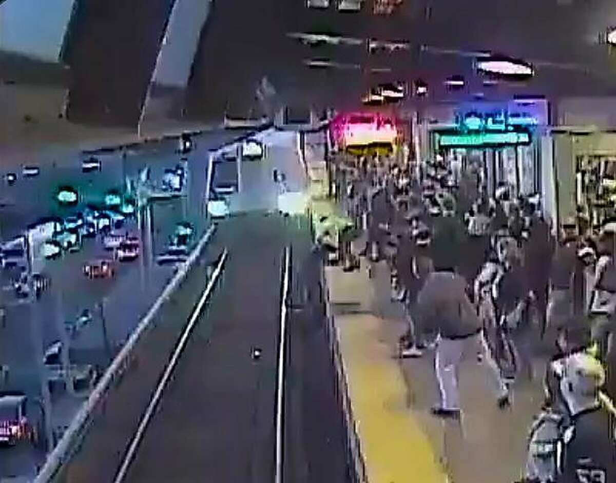 In this screen grab from a video posted on the SFBART Twitter page, BART employee John O'Connor is seen pulling a man up from the tracks moments before a train reaches him on Sunday, Nov. 3, 2019 in Oakland, Calif.