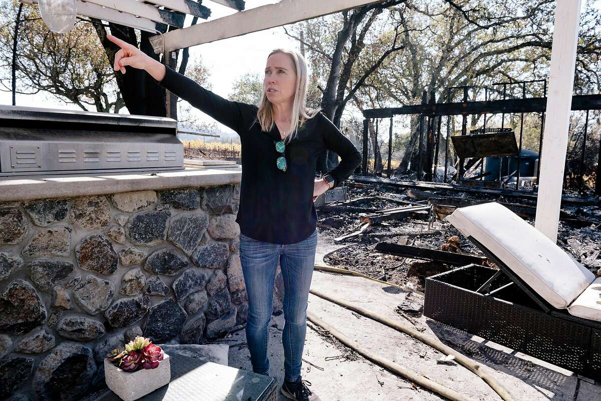 Annie Holden, who's home was spared by the Kincade Fire, looks round her neighbor's burned property at Chalk's Bend Vineyard in Healdsburg, California, on Monday, November 4th, 2019.