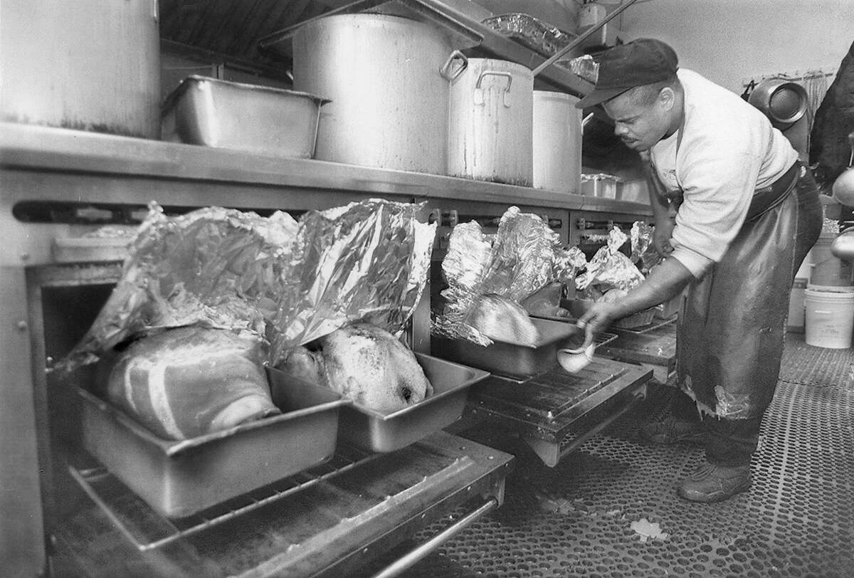 Frank Lipkins, a cook at Glide Memorial checks on the turkeys and hams which will be served for Thanksgiving dinner, November 21, 1994