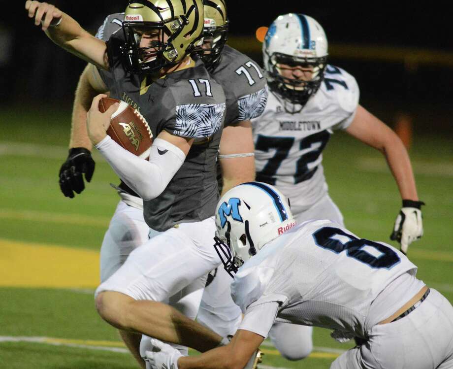 Hand senior quarterback Phoenix Billings is pursued by Middletown's Jacob Smith.  The Blue Dragons faced the No. 1 team in the state Friday night at the Surf Club in Madison. Photo: Dave Phillips / For Hearst Connecticut Media