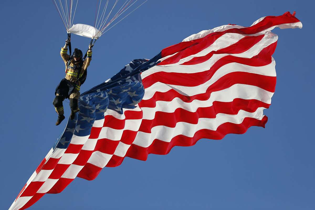 Skydiver guides down the American flag during a jump before the first half of an NCAA college football game between Fresno State Bulldogs and Air Force Falcons Saturday, Oct. 12, 2019, at Air Force Academy, Colo. (AP Photo/David Zalubowski)