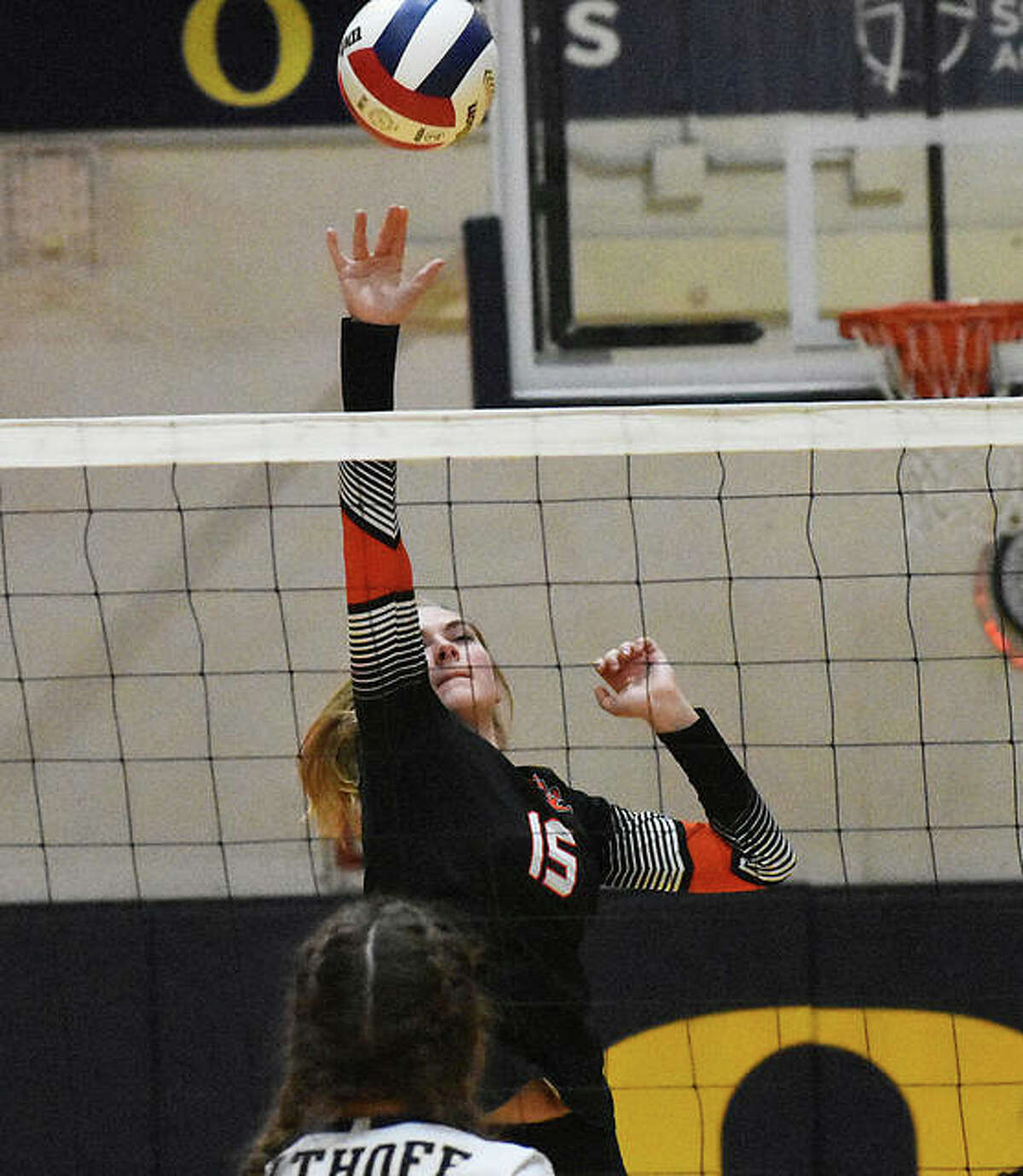 Edwardsville senior Lexie Curtis tips the ball over the net in the first game against Althoff.