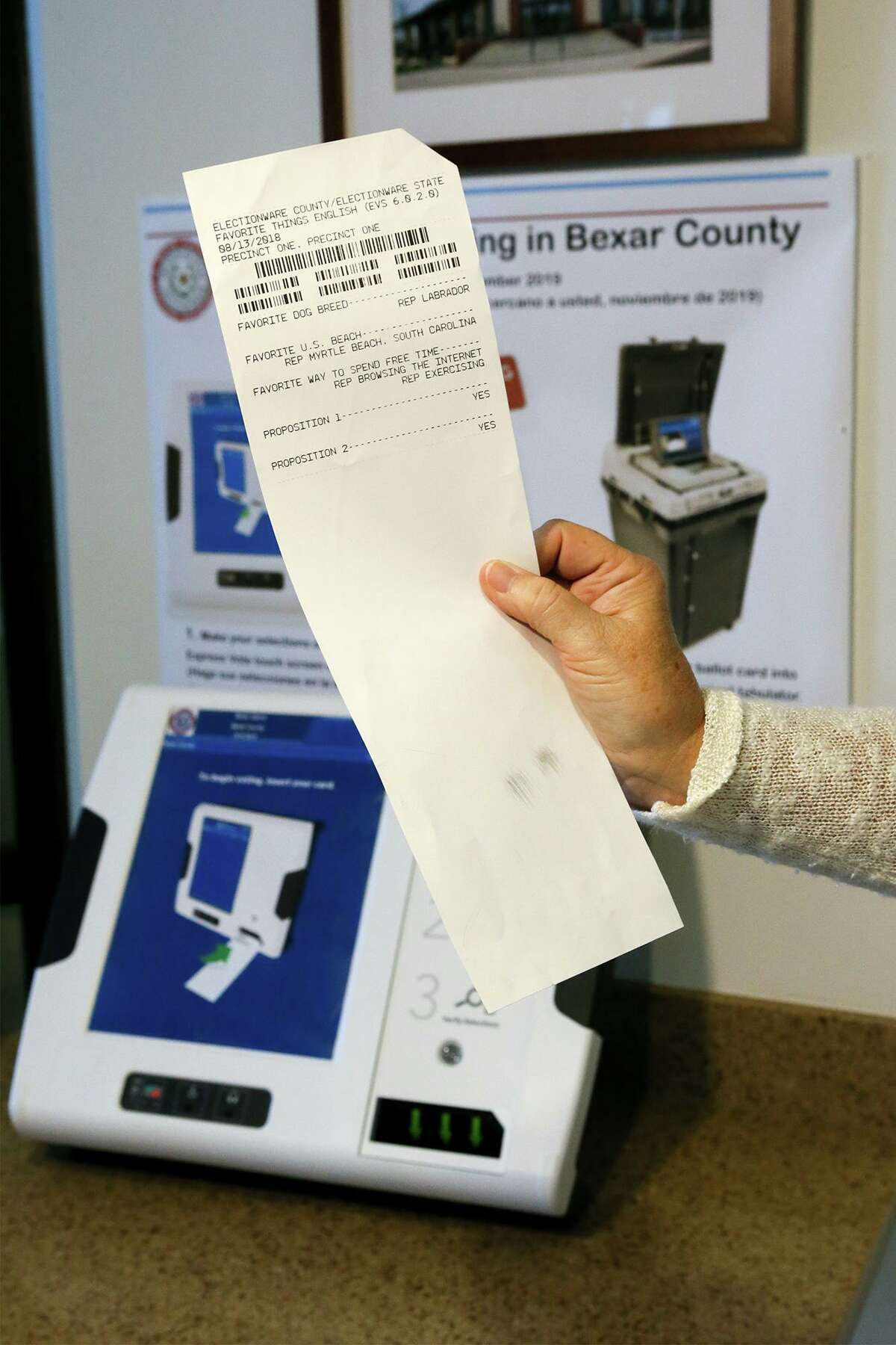 A sample printed ballot produced by the new ExpressVote ballot box in the background that will be used in Bexar County Elections as explained by Bexar County Elections Administrator Jacque Callanen at the Elections Department offices, 1103 S. Frio St., on Tuesday, Nov. 4, 2019. Votes will be input on screen and printed on this card, to be verified by the voter. The card will then be put into a tabulator where the votes will be recorded. Bexar County will use 2500 of the new machines at 264 polling sites countrywide and for the first time, voter can cast ballots anywhere in Bexar County on Election Day.
