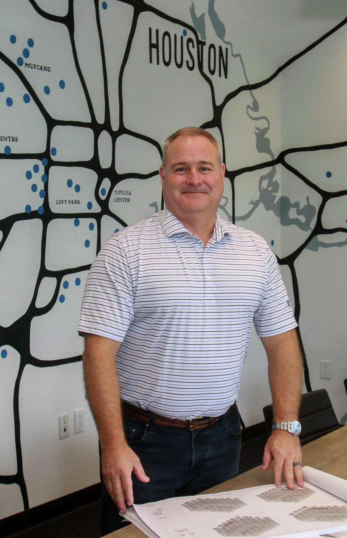 Shawn McAlpin, CEO of Burton Construction in a conference room with a map showing the location of some of their projects in their office in Houston on September 30, 2019.