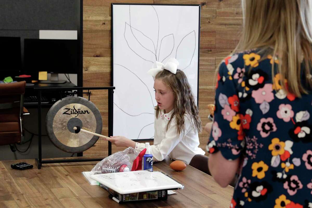 Charlotte Hron (cq), age six, rings a gong normally reserved for celebrating big sales, as her mom Bridget Hron, right, looks on at the monthly team building meeting at ThoughtTrace in their company offices Thursday, Sep. 26, 2019 in Houston, TX.