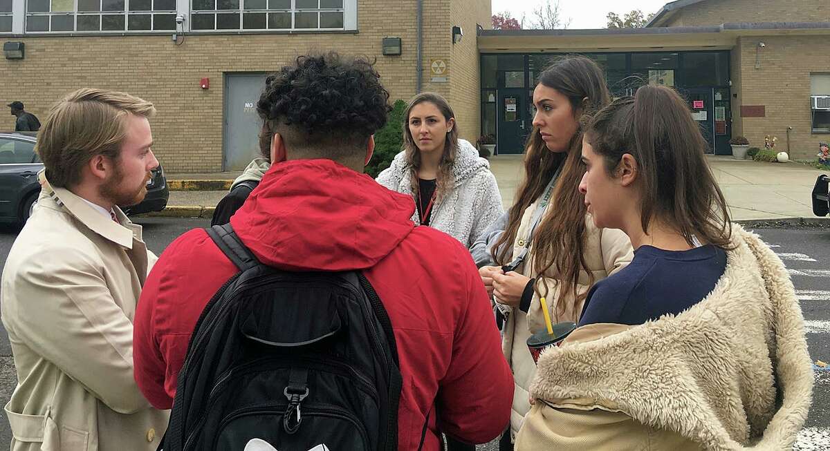 Sacred Heart students talk to Carlos Ruiz and Alessandra Leone, two of the organizers of PioneerVotes, a SHU student voting initiative. Student Maria Bonaddio said she registered to vote, but was turned away at John Winthrop Elementary in Bridgeport on Tuesday, Nov. 5, 2019.