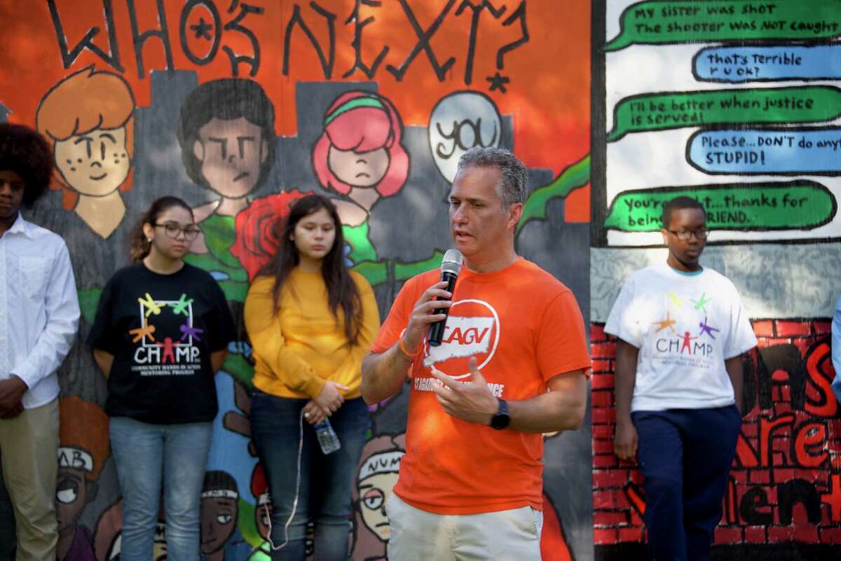 Jeremy Stein, executive director of CT Against Gun Violence, speaks to the crowd gathered at the unveiling of the Aim Higher mural in Wheeler Park Saturday.