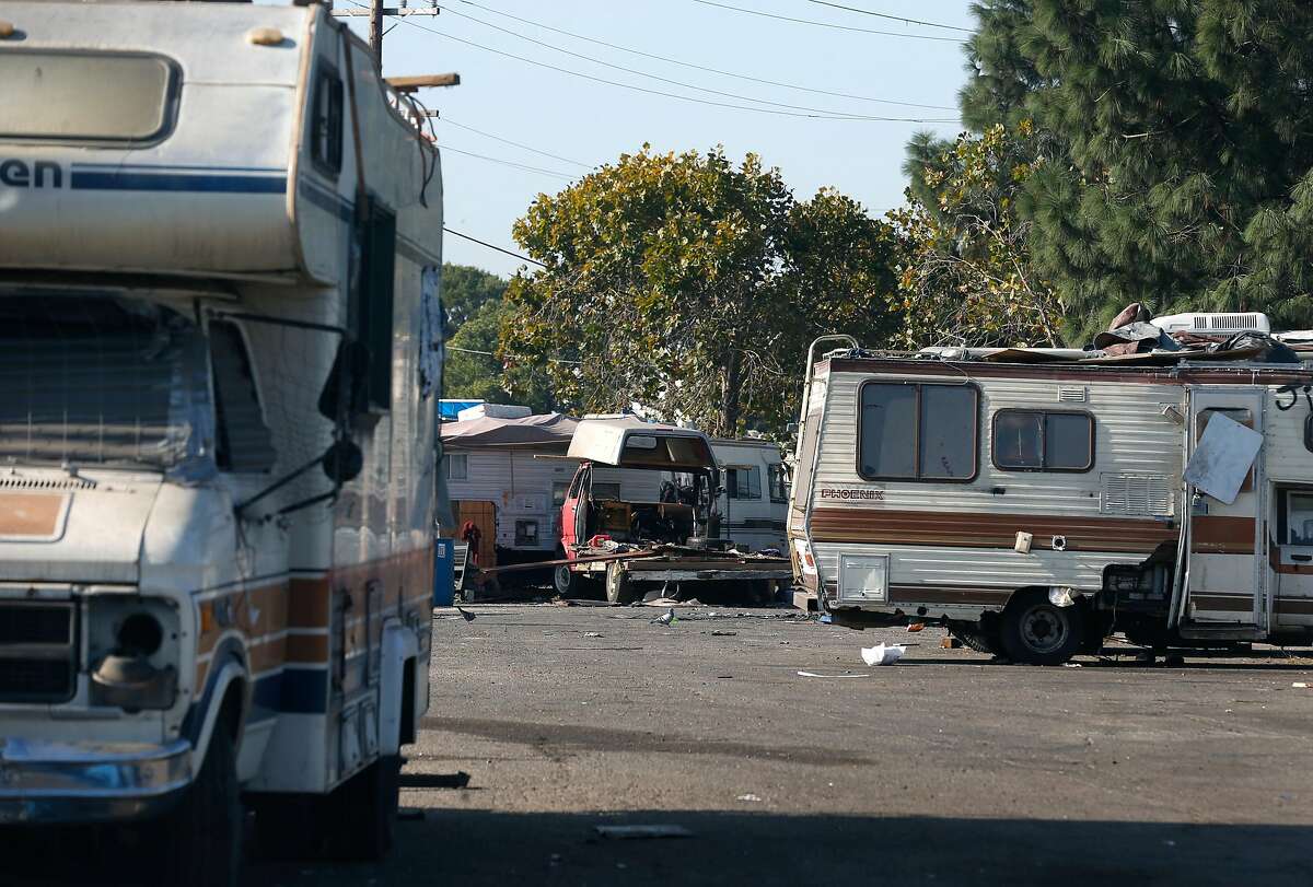 Recreational vehicles are parked at a homeless encampment where trash and debris have been partially removed in front of the Home Depot near High Street in Oakland, Calif. on Tuesday, Nov. 5, 2019. Oakland officials have recently cleared out about 250 tons of debris from the site but another 50 tons remain.