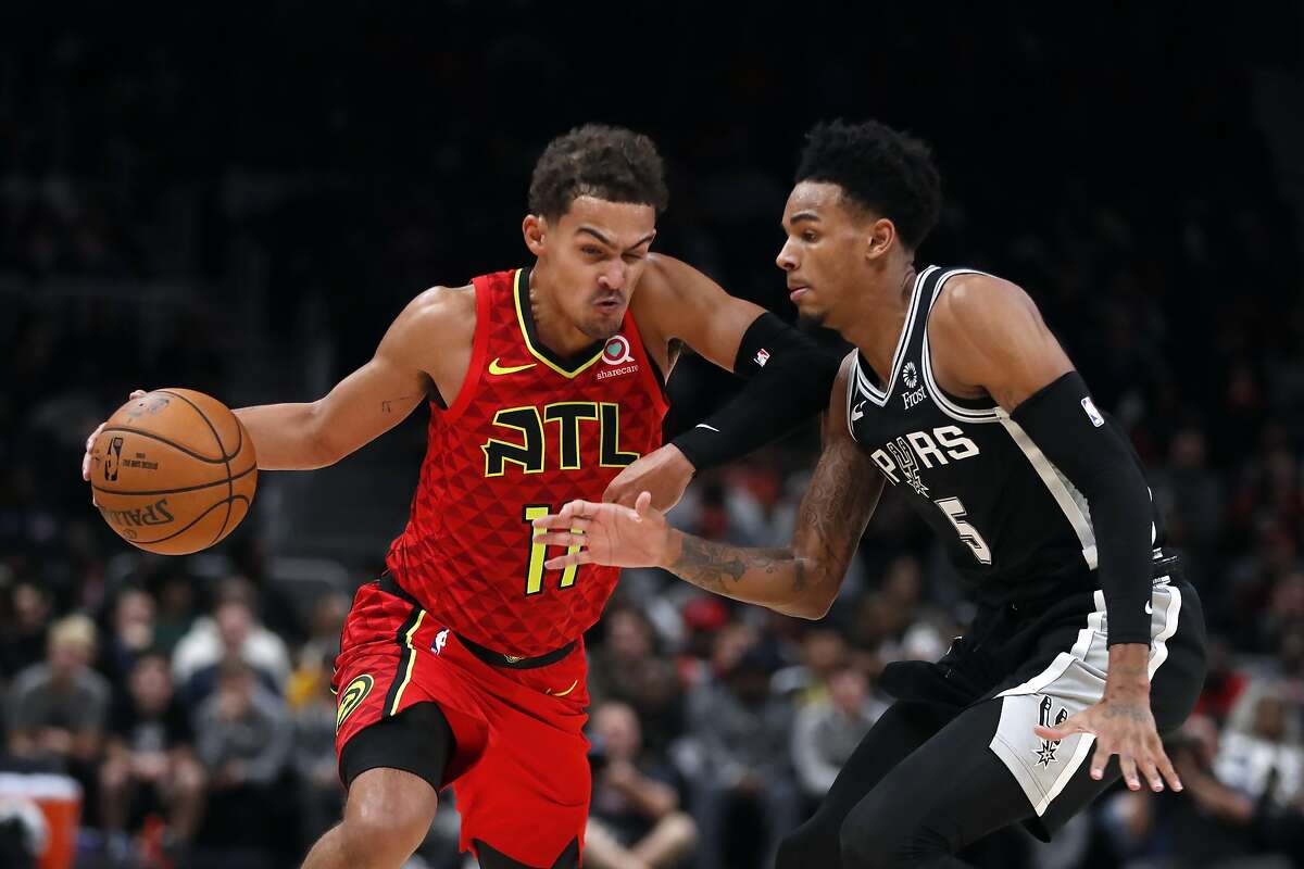Atlanta Hawks guard Trae Young (11) drives against San Antonio Spurs guard Dejounte Murray (5) in the second half of an NBA basketball game Tuesday, Nov. 5, 2019, in Atlanta. Young says Murray is "super underrated." (AP Photo/John Bazemore)