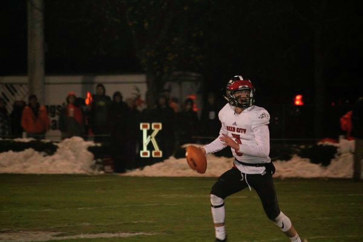 Reed City quarterback Jeffrey Samuels scrambles to find a receiver in Friday's playoff game at Kingsley. (Herald Review photo/John Raffel)