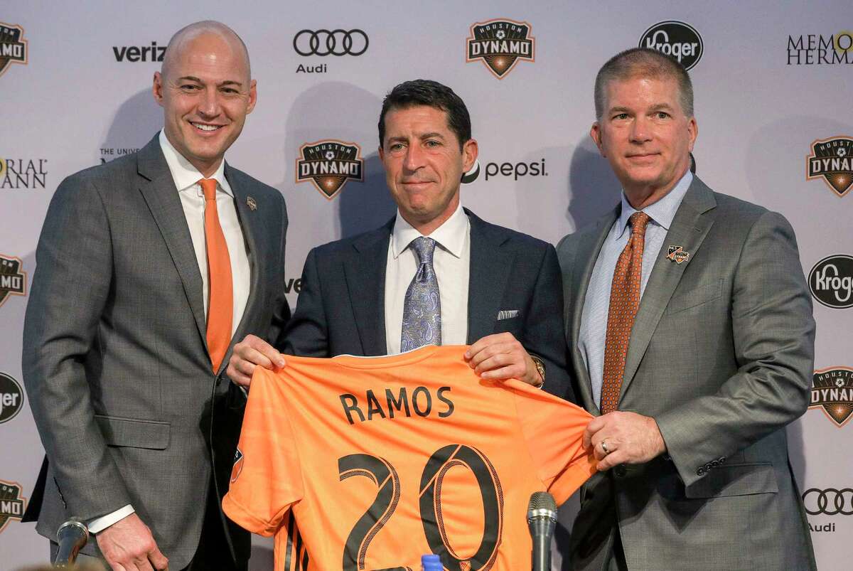 Matt Jordan, from left, senior vice president and general manager of the Houston Dynamo, Tab Ramos, Houston Dynamo head coach, and John Walker, president of business operations, pose for photos during a press conference at BBVA Stadium on Wednesday, Nov. 6, 2019, in Houston. The team formally introduced Ramos, who was previously the U.S. men's U-20 head coach.