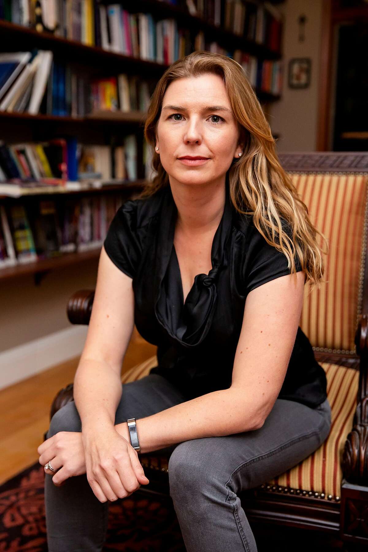 Christina Chalmers sits for a portrait in Oakland, Calif. on Wednesday, Nov. 6, 2019. Chalmers lives just doors from away from the Orinda home that became the site of a deadly shooting incident on Oct. 30. That incident spurred her to do deeper research and has since learned that there have been numerous shooting incidents at other AirBnB locations across California and other states.