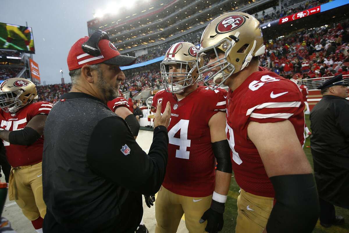 FILE: Offensive Line Coach John Benton, Joe Staley #74 and Mike McGlinchey #69 of the San Francisco 49ers talk on the sideline during the game against the Seattle Seahawks at Levi's Stadium on December 16, 2018 in Santa Clara.