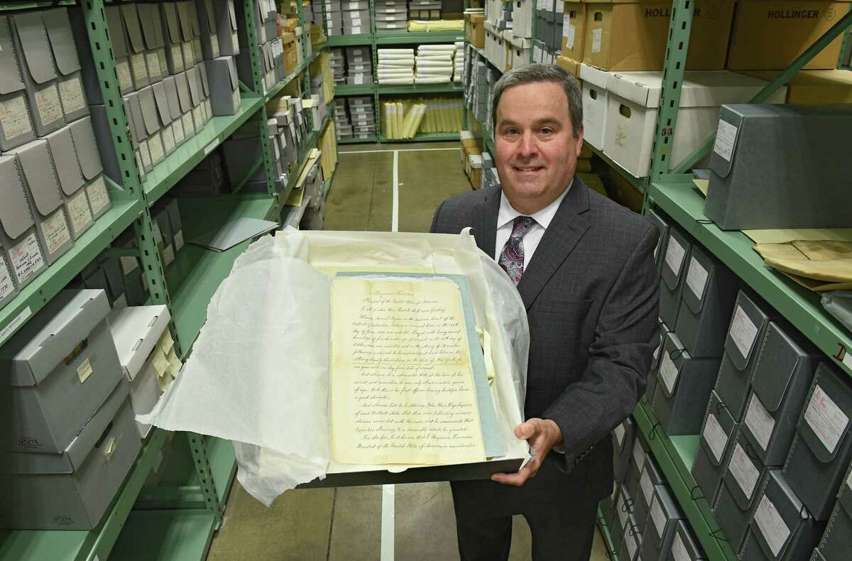 Deputy County Clerk Craig Carlson holds the presidential pardon of Samuel Ryder by President Benjamin Harrison in the vault at the Albany County Hall of Records on Friday, Oct. 11, 2019 in Albany, N.Y. (Lori Van Buren/Times Union)