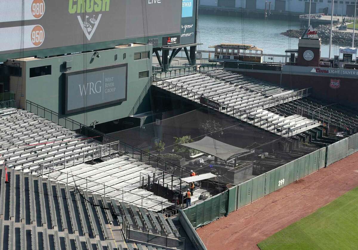 A construction crew dismantles a section of bleachers behind center field at Oracle Park on Thursday.