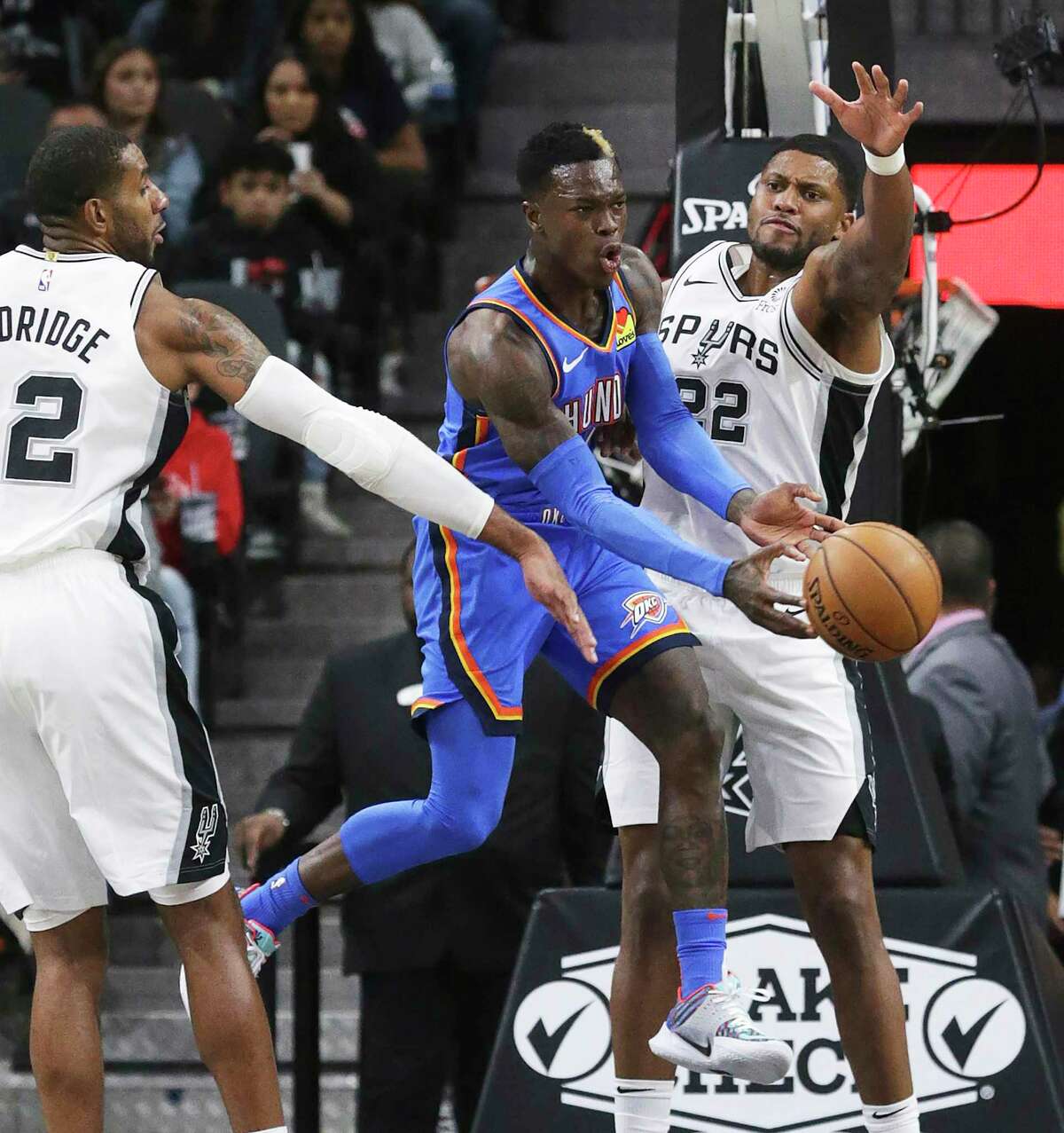 Dennis Schroder passes the ball out from under LaMarcus Aldridge and Rudy Gay as the Spurs hosts the Thunder at the AT&T Center on Nov. 7, 2019.