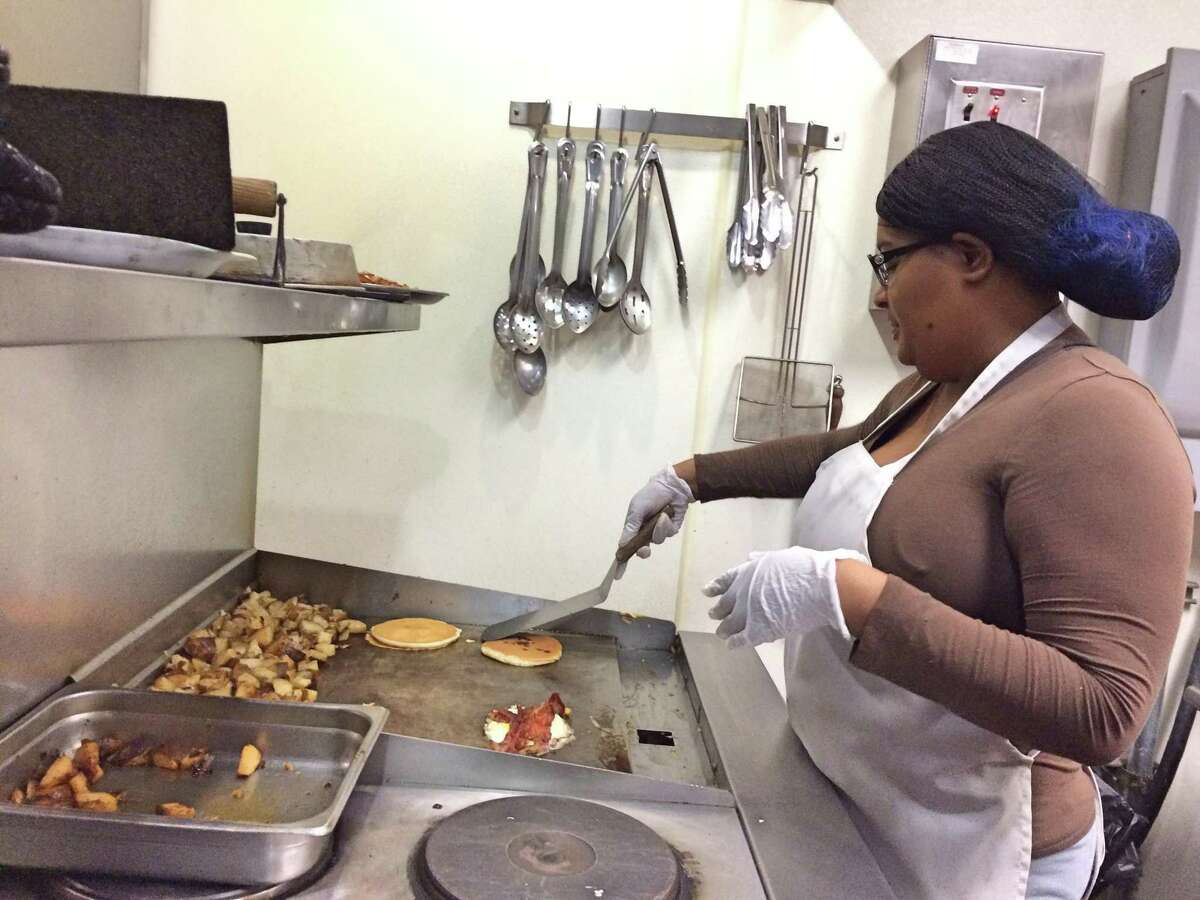 Kabrena Robinson, who receives services from the Kennedy Center, works the grill at the center's Soups and Such cafe.