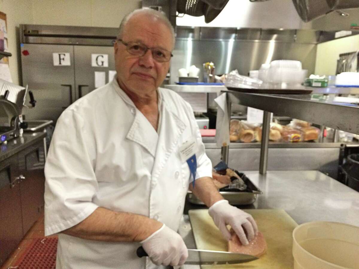 Soups and Such assistant manager Vincent LaRocca preps chicken breasts for the lunch service at the Kennedy Center's Soups and Such cafe.