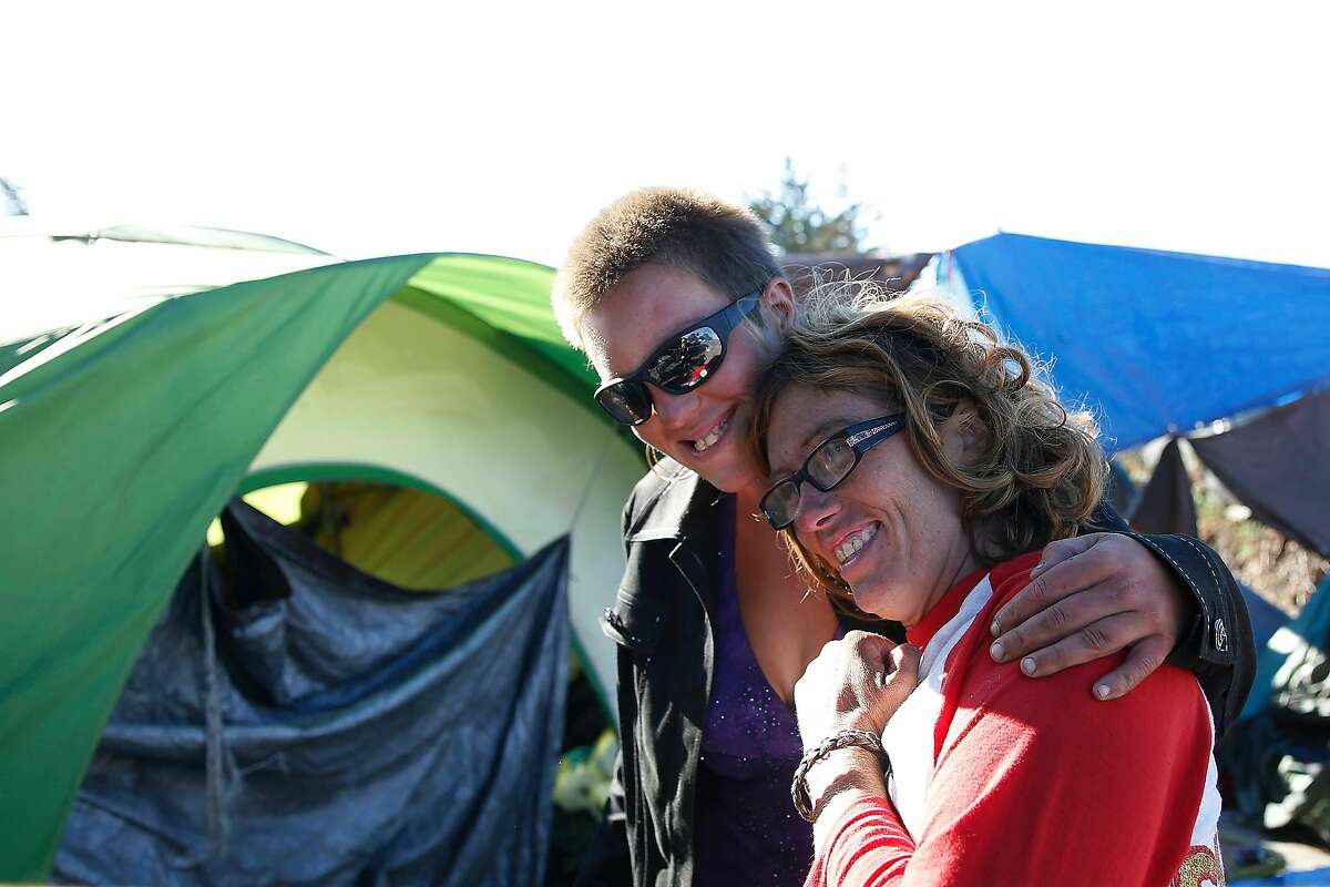 Angel Brown gives Shawna Garcia a hug as they stand outside their tents at a homeless encampment on Caltrans property on Tuesday, October 22, 2019 in Berkeley, Calif.