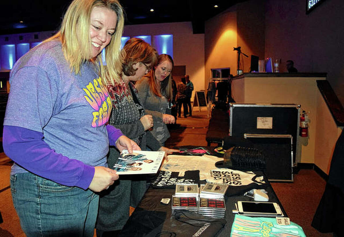 Ramona Haley of Jacksonville looks over Citizen Way merchandise Friday at First Christian Church during the Love is a Lion Tour with Citizen Way.