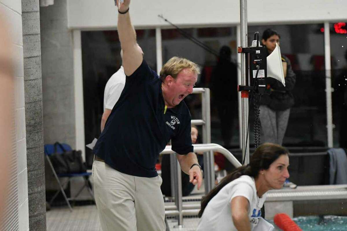 Wilton coach Todd Stevens does his best to motivate a swimmer at Tuesday's FCIAC girls swimming championship in Greenwich.